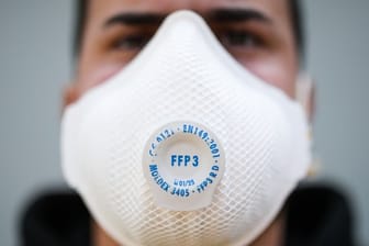 Ein junger Mann trägt eine Atemschutzmaske