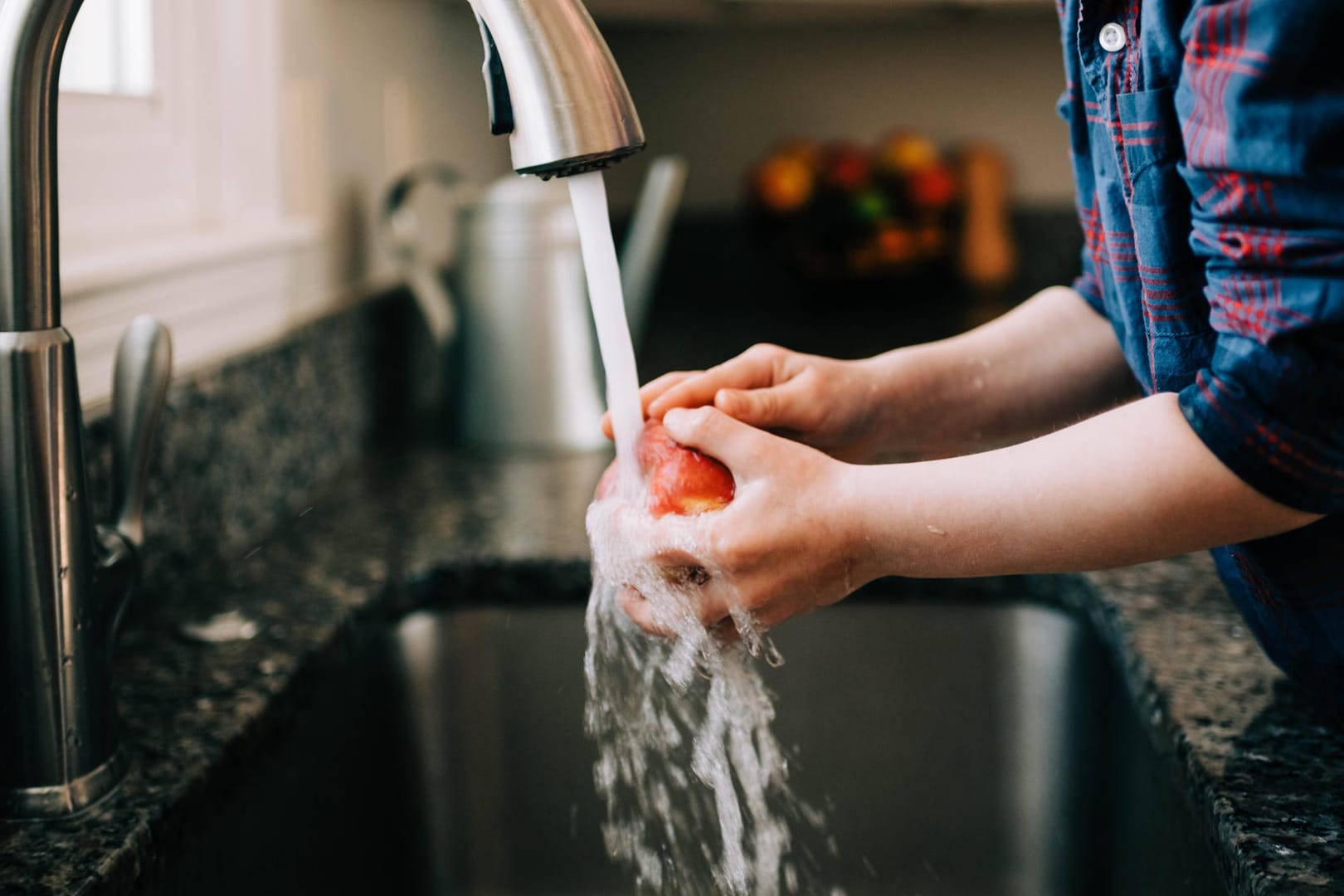 Kind wäscht Apfel: Durch die Klimakrise werden bei der Wasserversorgung auch in Deutschland Konflikte entstehen.