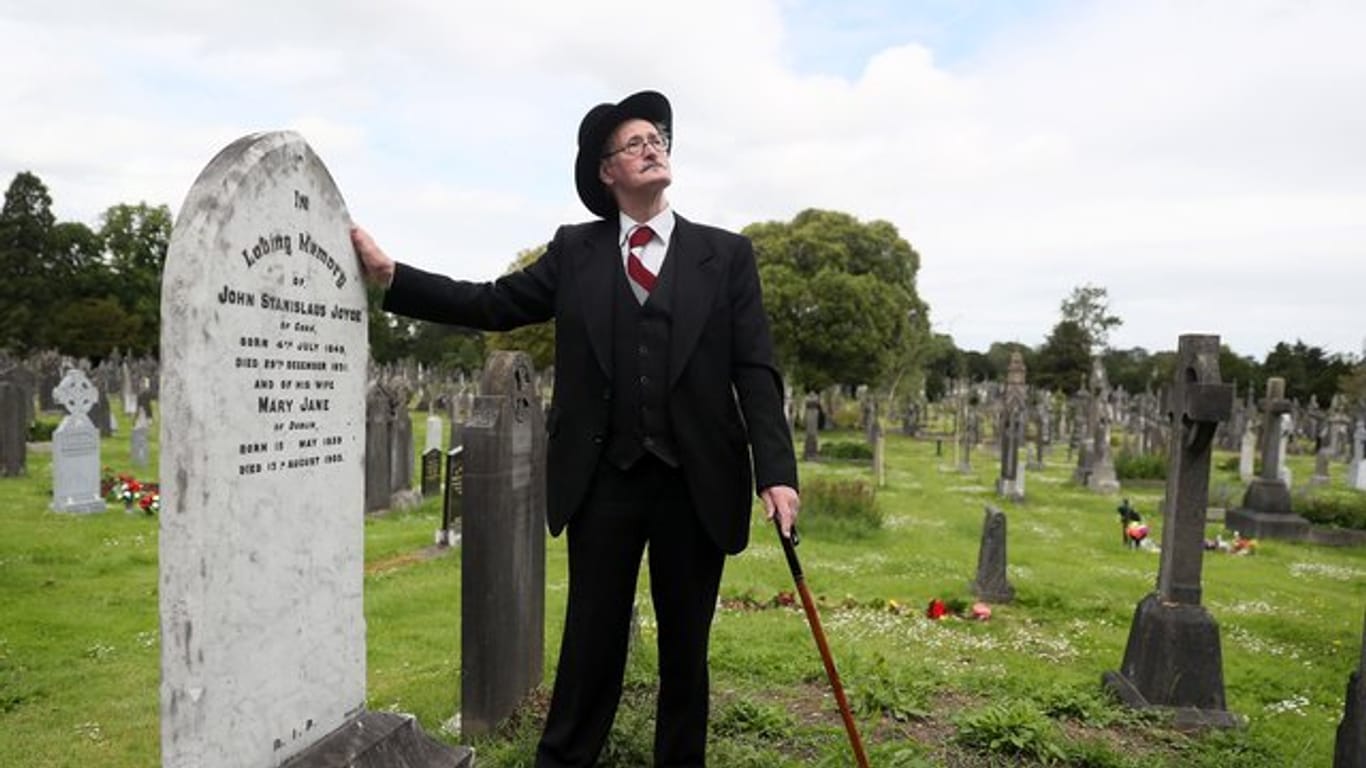 Ein James-Joyce-Darsteller am Grab des Schriftstellers James Joyce und seiner Frau in Dublin (2019).