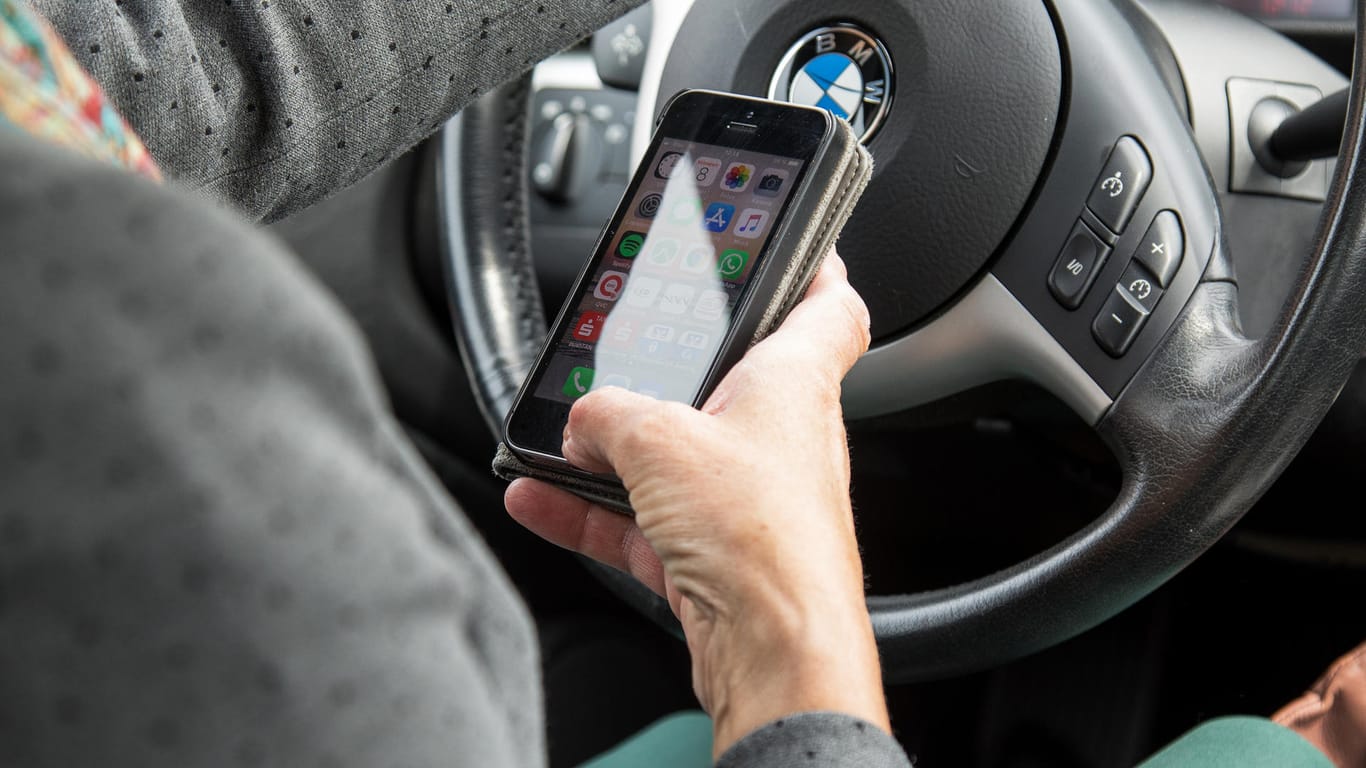 Keine gute Idee: Gleichzeitig Autofahren und Nachrichten auf dem Handy checken erhöht das Unfallrisiko deutlich.