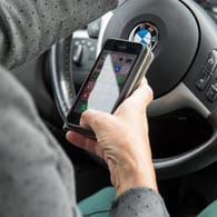 Keine gute Idee: Gleichzeitig Autofahren und Nachrichten auf dem Handy checken erhöht das Unfallrisiko deutlich.