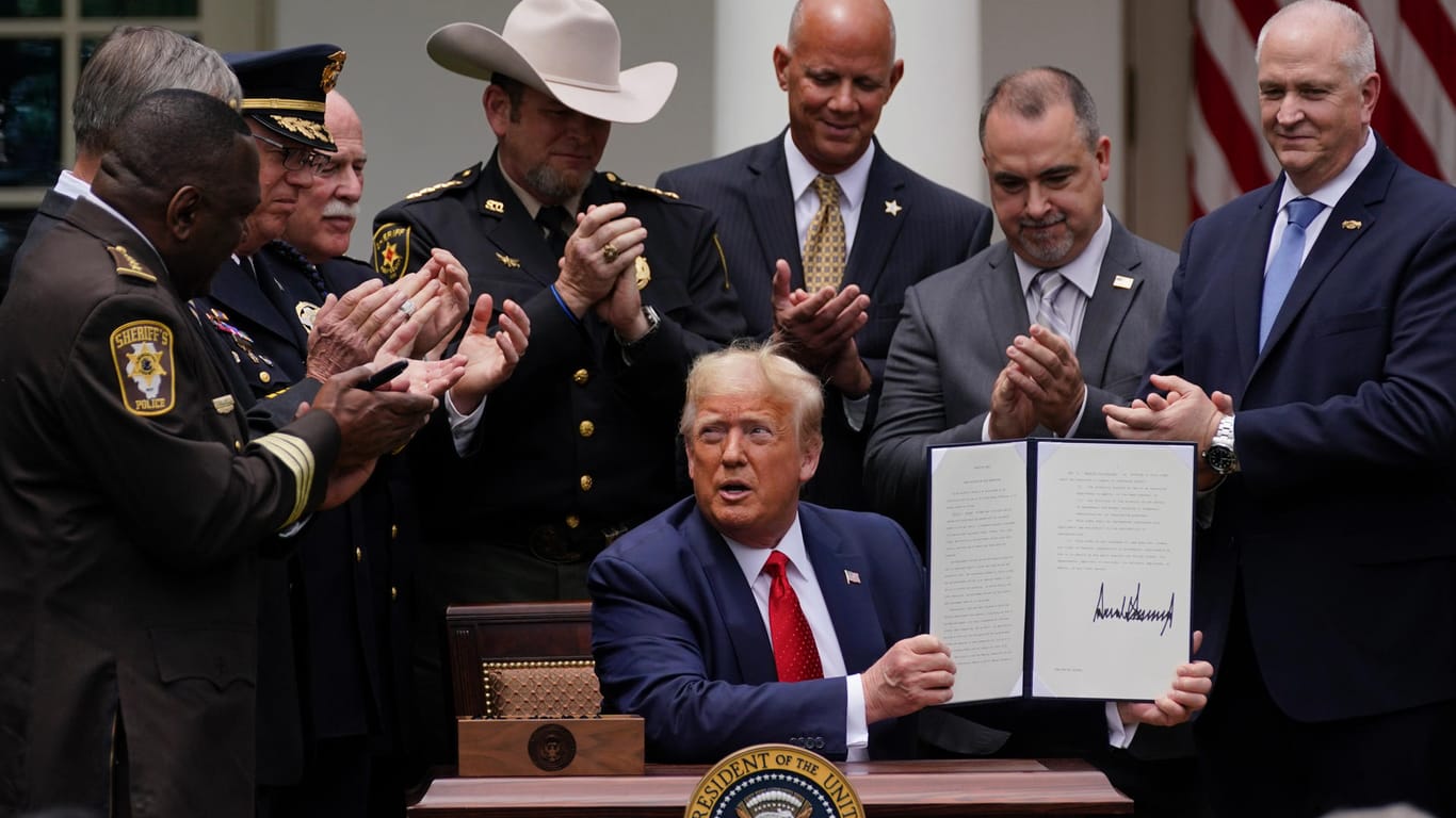 Lässt sich für seine Polizeireform feiern: US-Präsident Donald Trump mit Gesetzteshütern im Garten des Weißen Hauses.