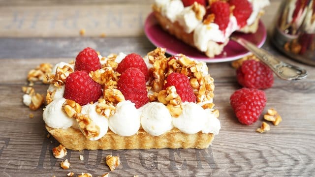 Dessert: Himbeeren krönen diese Mürbeteig-Tarte mit Mascarpone-Sahne-Creme und Mandelkrokant.