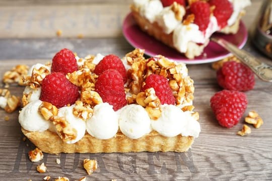 Dessert: Himbeeren krönen diese Mürbeteig-Tarte mit Mascarpone-Sahne-Creme und Mandelkrokant.