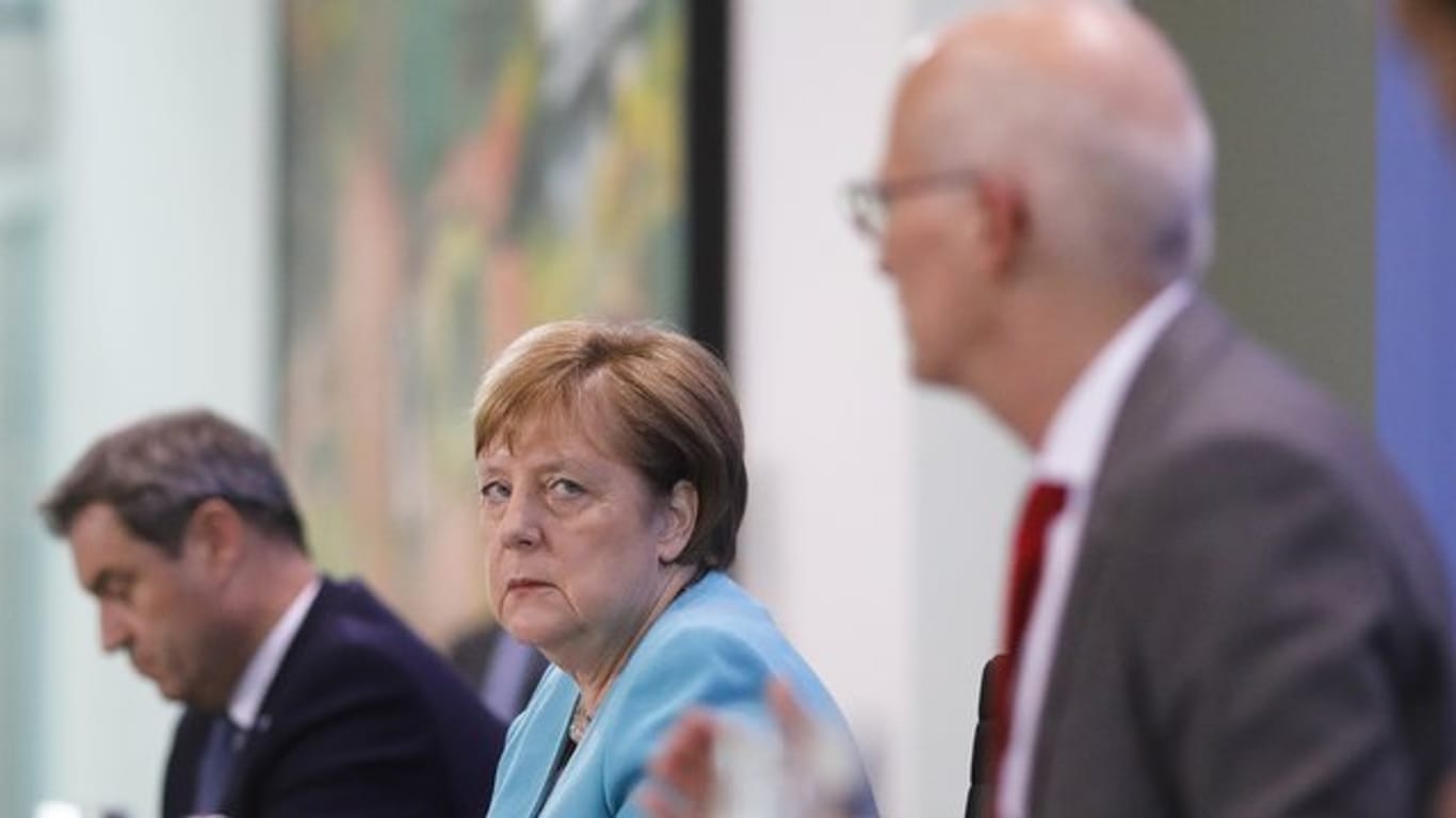 Bundeskanzlerin Angela Merkel nimmt zusammen mit dem bayerischen Ministerpräsident Markus Söder und Hamburgs Erstem Bürgermeister Peter Tschentscher nach Abschluss der Beratungen an einer Pressekonferenz teil.