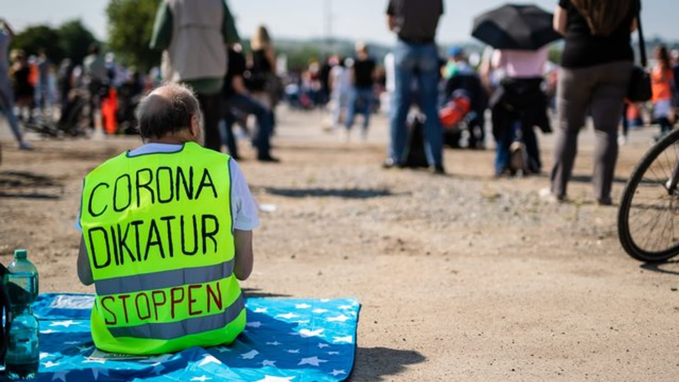 Ein Demonstrant trägt eine Warnweste mit der Aufschrift "Corona Diktatur stoppen": In Deutschland kursieren einige Verschwörungstheorien zum Coronavirus.