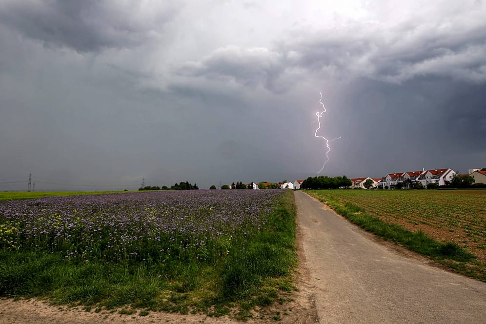 Gewitter über einem Dorf im Rhein-Main-Gebiet: Das schlechte Wetter erwischt zunächst den Süden und Westen Deutschlands. (Archivbild)