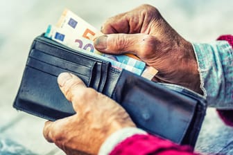 Die Hände einer Rentnerin holen Geldscheine aus einer Brieftasche (Symbolbild). Das Rentenniveau in Deutschland liegt bei rund 48 Prozent.