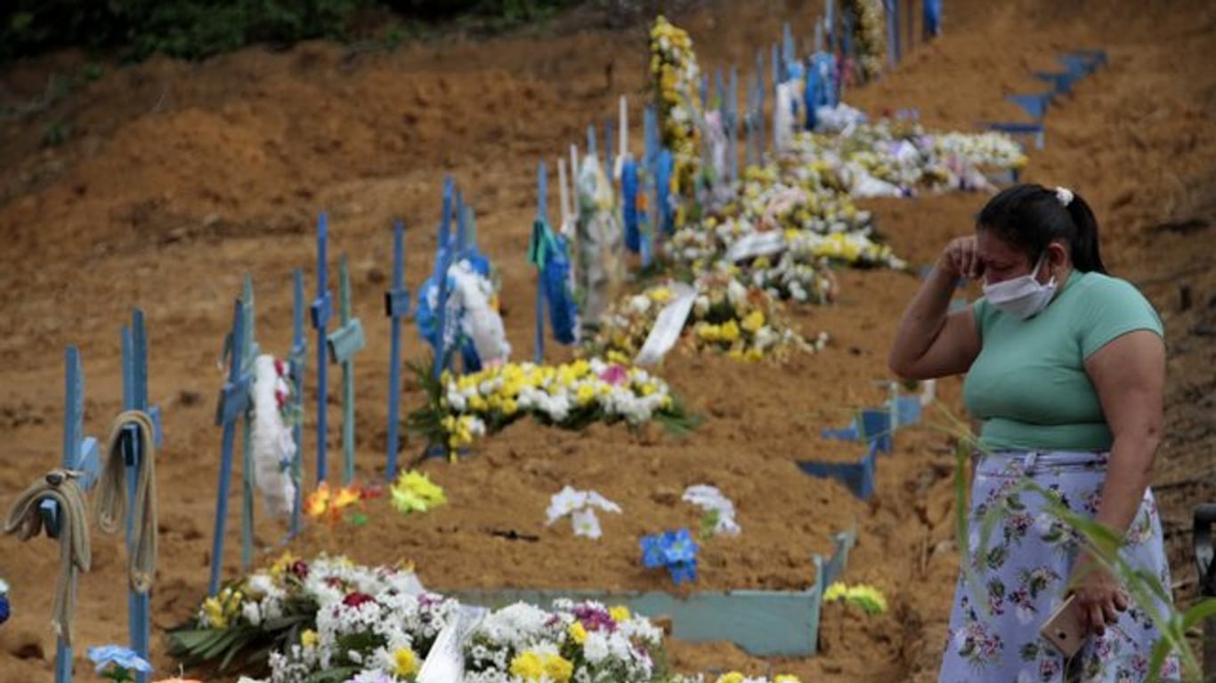 Eine Frau trauert an einem Grab auf einem Friedhof in Manaus.