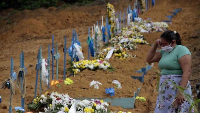 Eine Frau trauert an einem Grab auf einem Friedhof in Manaus. Eine Frau trauert an einem Grab auf einem Friedhof in Manaus.