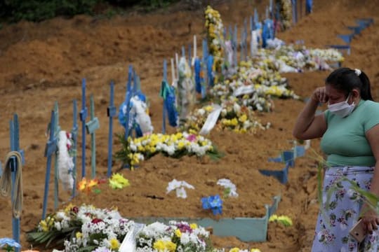 Eine Frau trauert an einem Grab auf einem Friedhof in Manaus.