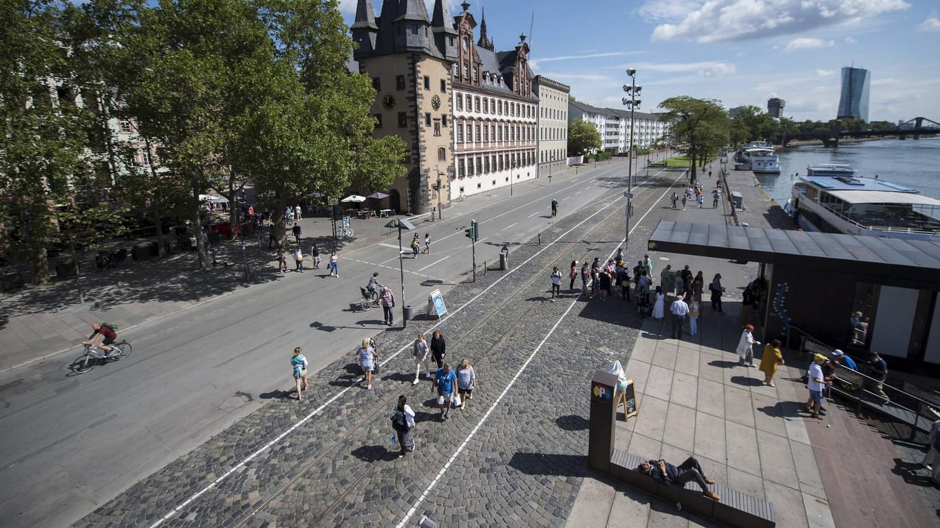 Fußgänger und Radfahrer sind auf dem Mainkai in Frankfurt unterwegs: Ab dem 1. September sollen hier wieder Autos fahren dürfen.