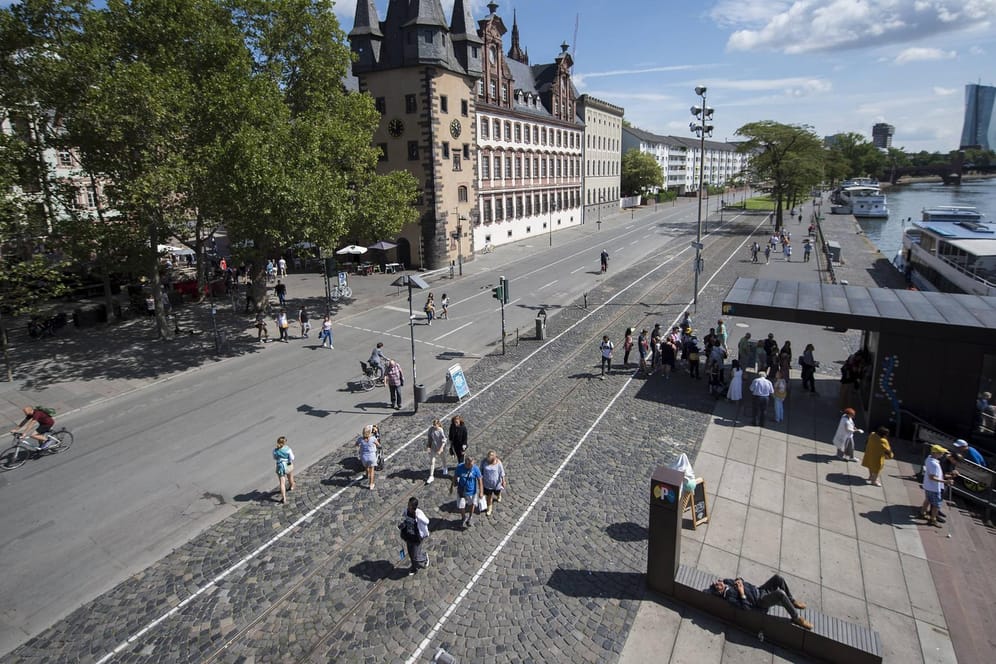 Fußgänger und Radfahrer sind auf dem Mainkai in Frankfurt unterwegs: Ab dem 1. September sollen hier wieder Autos fahren dürfen.