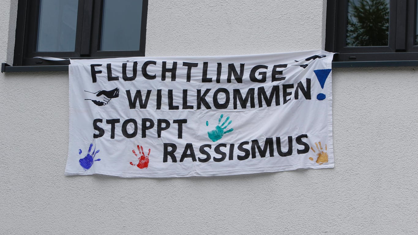 Auf einem Banner steht die Aufschrift "Flüchtlinge willkommen! Stoppt Rassismus" (Symbolbild): In Wolfsburg soll am Weltflüchtlingstag auf die Situation von Flüchtlingen aufmerksam gemacht werden.