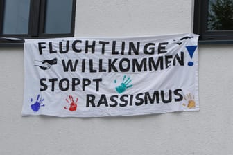 Auf einem Banner steht die Aufschrift "Flüchtlinge willkommen! Stoppt Rassismus" (Symbolbild): In Wolfsburg soll am Weltflüchtlingstag auf die Situation von Flüchtlingen aufmerksam gemacht werden.