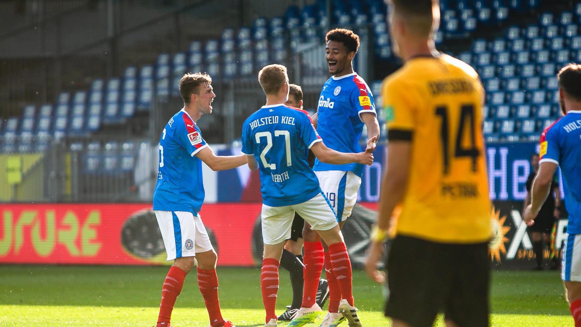 Die Kieler Spieler Jonas Meffert (l-r), Finn Porath und Torschütze Emmanuel Iyoha feiern das 1:0 für Holstein Kiel.