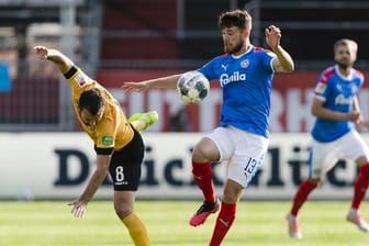 Dresdens Josef Husbauer (l) kommt gegen den Kieler Salih Özcan ins Straucheln.