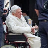Benedikt XVI. besucht kranken Bruder: Der emeritierte Papst Benedikt XVI wird mit einem Rollstuhl in einen Bus geschoben.