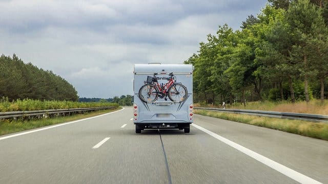 Ein Wohnmobil mit Fahrrädern am Heck auf der Autobahn A24.