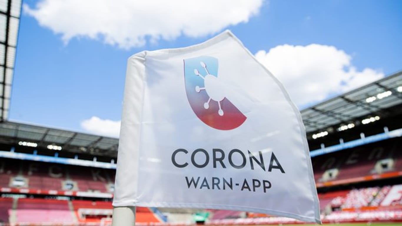 Ein Hinweis auf die Corona-Warn-App auf einer Eckfahne im im RheinEnergieStadion in Köln.