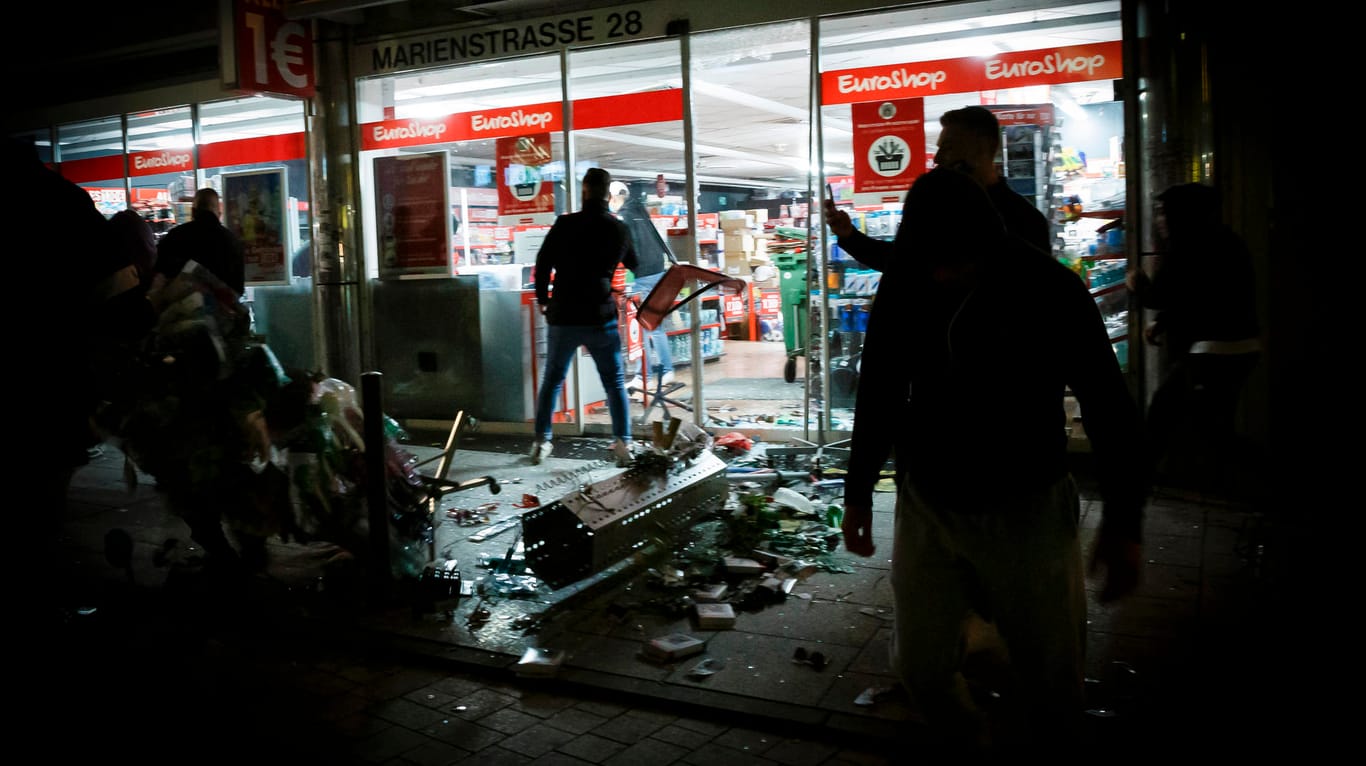 Menschen stehen vor einem geplünderten Geschäft in der Marienstraße: Viele Polizisten wurden bei der Randale in Stuttgart verletzt.
