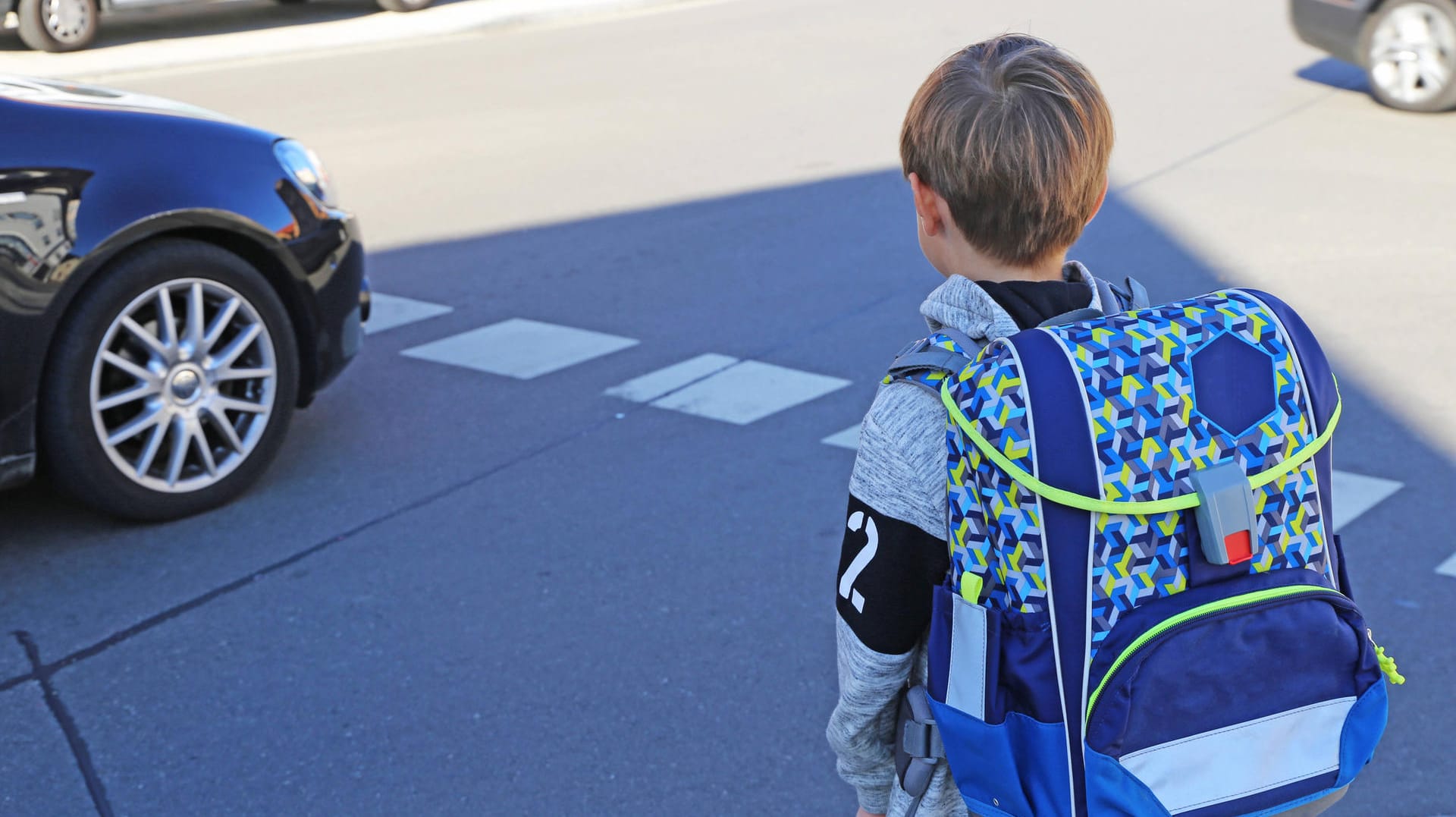 Ein Schulkind will eine Straße überqueren (Symbolbild): Nach Corona-Fällen können zwei Schulen in Wuppertal wieder öffnen. Ein Schulkind will eine Straße überqueren (Symbolbild): Nach Corona-Fällen können zwei Schulen in Wuppertal wieder öffnen.
