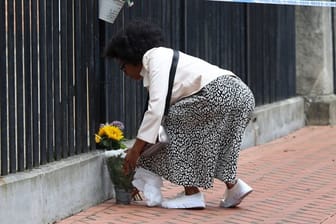 Eine Frau legt zum Gedenken an die Opfer im Stadtzentrum von Reading Blumen nieder.