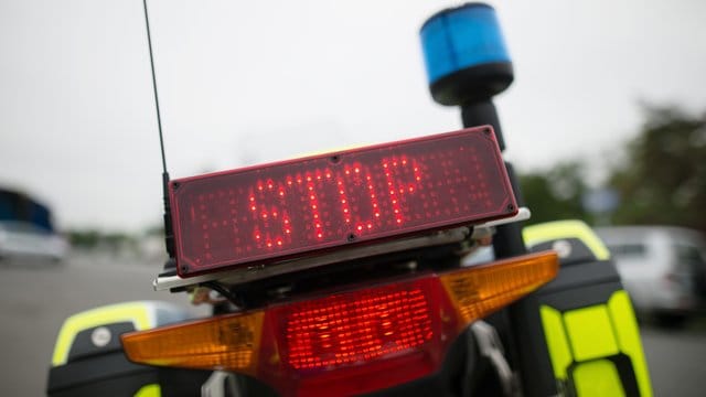 "Stop" steht auf einer Anzeige eines Polizeimotorrads