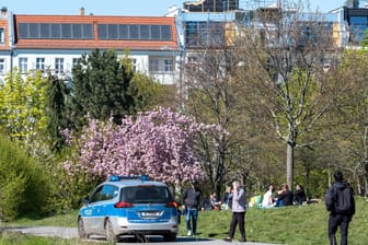 Ein Streifenwagen der Berliner Polizei fährt durch den Mauerpark: Bei gutem Wetter wollen die Berliner Beamten in Parks die Einhaltung der Corona-Regeln kontrollieren.