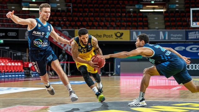 Martin Hermannsson (l) und Kenneth Ogbe (r) von Alba Berlin verteidigen gegen Oldenburgs Tyler Larson. Martin Hermannsson (l) und Kenneth Ogbe (r) von Alba Berlin verteidigen gegen Oldenburgs Tyler Larson.