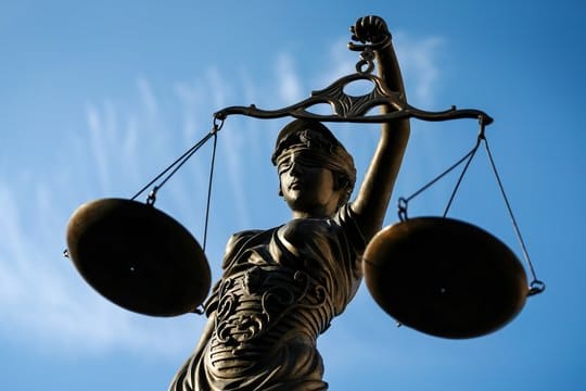 Eine Statue der Justitia hält eine Waage in ihrer Hand: Ein ehemaliger Trainer steht wegen Missbrauchs vor Gericht.