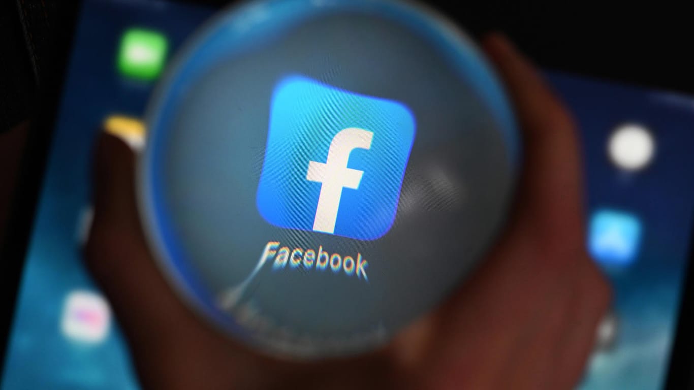 Eine Person schaut durch eine Glaskugel auf einem Tablet auf die Facebook App: Am 23.06.2020 will der Bundesgerichtshof (BGH) im Streit zwischen Facebook und dem Bundeskartellamt wegen der Sammlung von Nutzerdaten verhandeln.