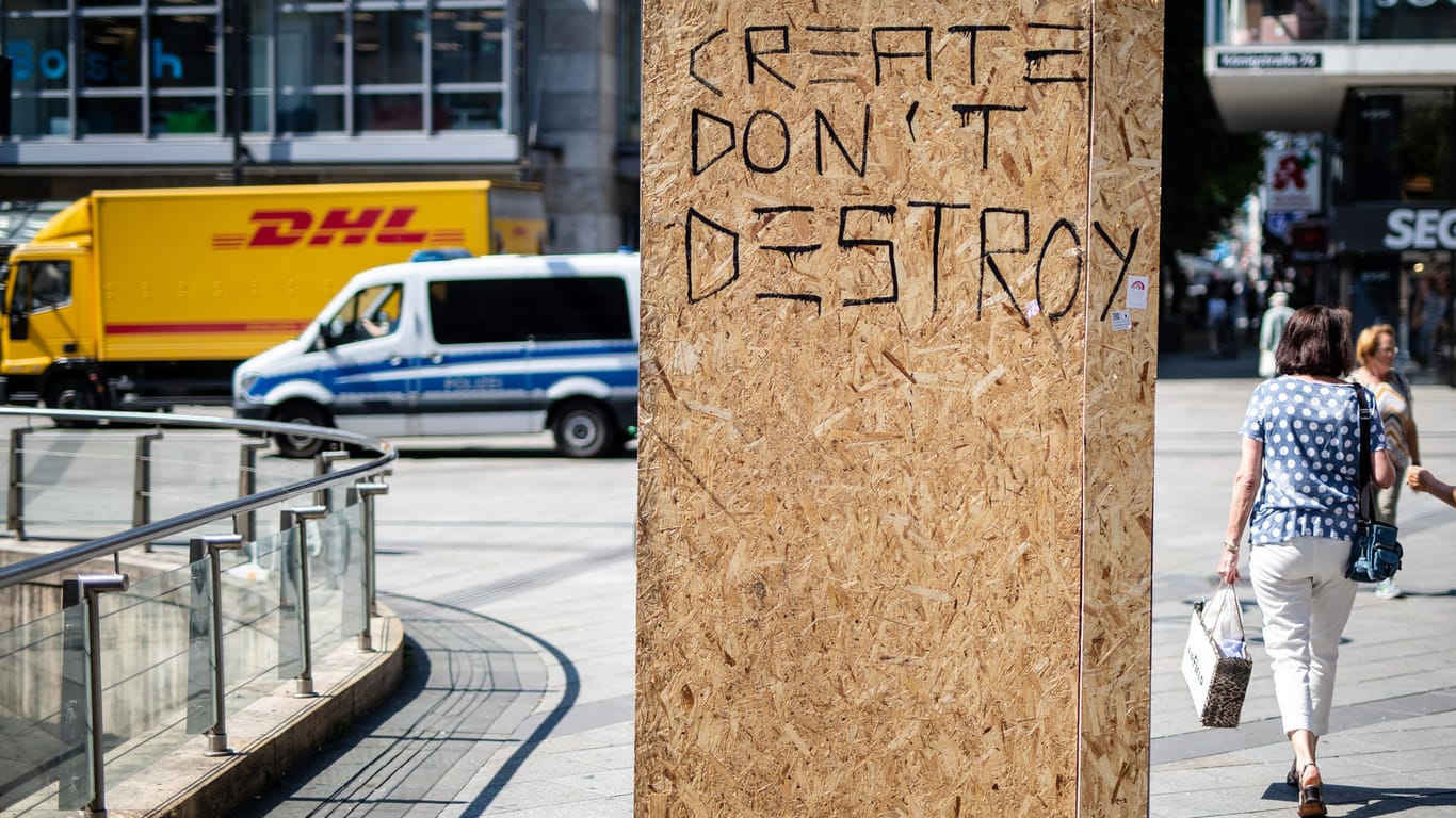 Stuttgart: "Create - Don·t Destroy"· steht auf einer Holzwand, die an eine zerstörte Werbeanzeige angebracht wurde.