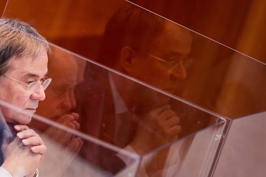 Armin Laschet sitzt in einer Box aus Plexiglas im Plenum des Landtags.