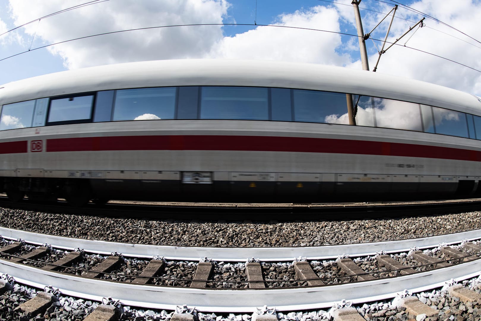 Weiße Schienen gegen Hitze: Ein ICE der Deutschen Bahn fährt auf der Hochgeschwindigkeitsstrecke zwischen Hannover und Würzburg an einem Gleis mit weißem Farbanstrich vorbei.