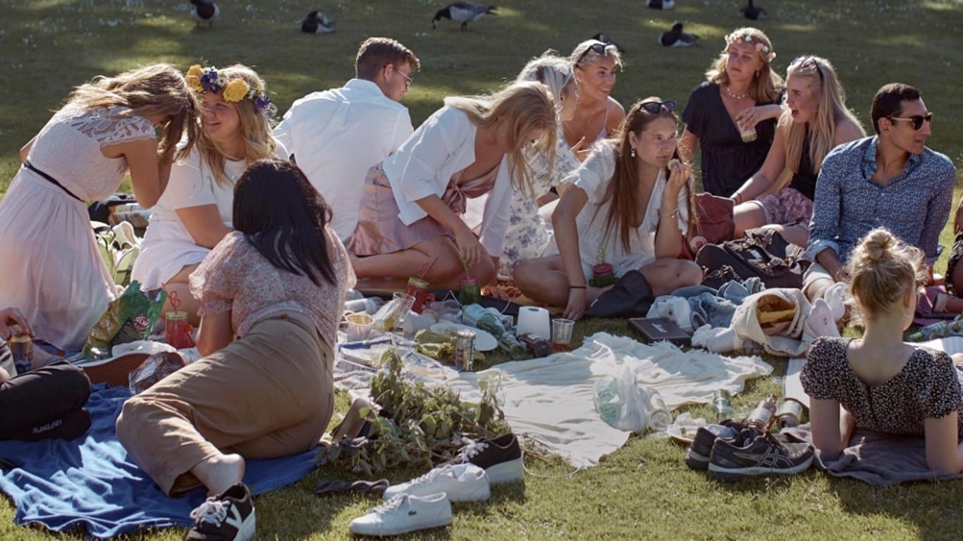 Schweden feiert Mittsommer: In Stockholm picknickt eine Gruppe junger Menschen in einem Park.