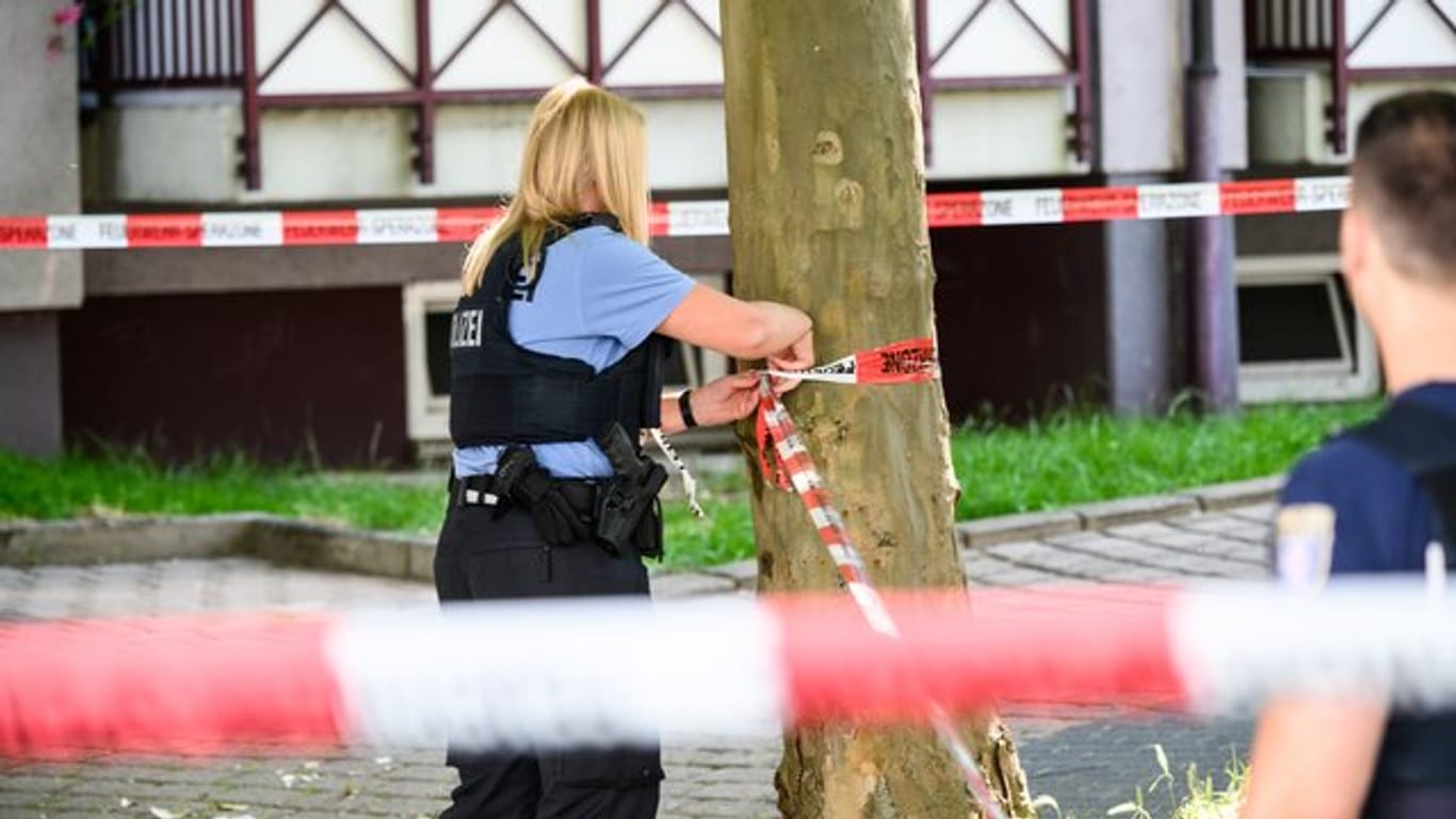 Eine Polizistin sperrt den Tatort in Frankfurt ab: Dort soll ein Mann auf seinen Bruder geschossen haben.