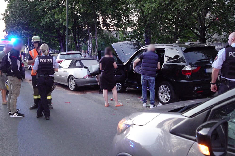 Einsatzkräfte der Polizei stehen am Tatort in Düsseldorf: Drei Männer sollen hier in einem BMW überfallen worden sein.