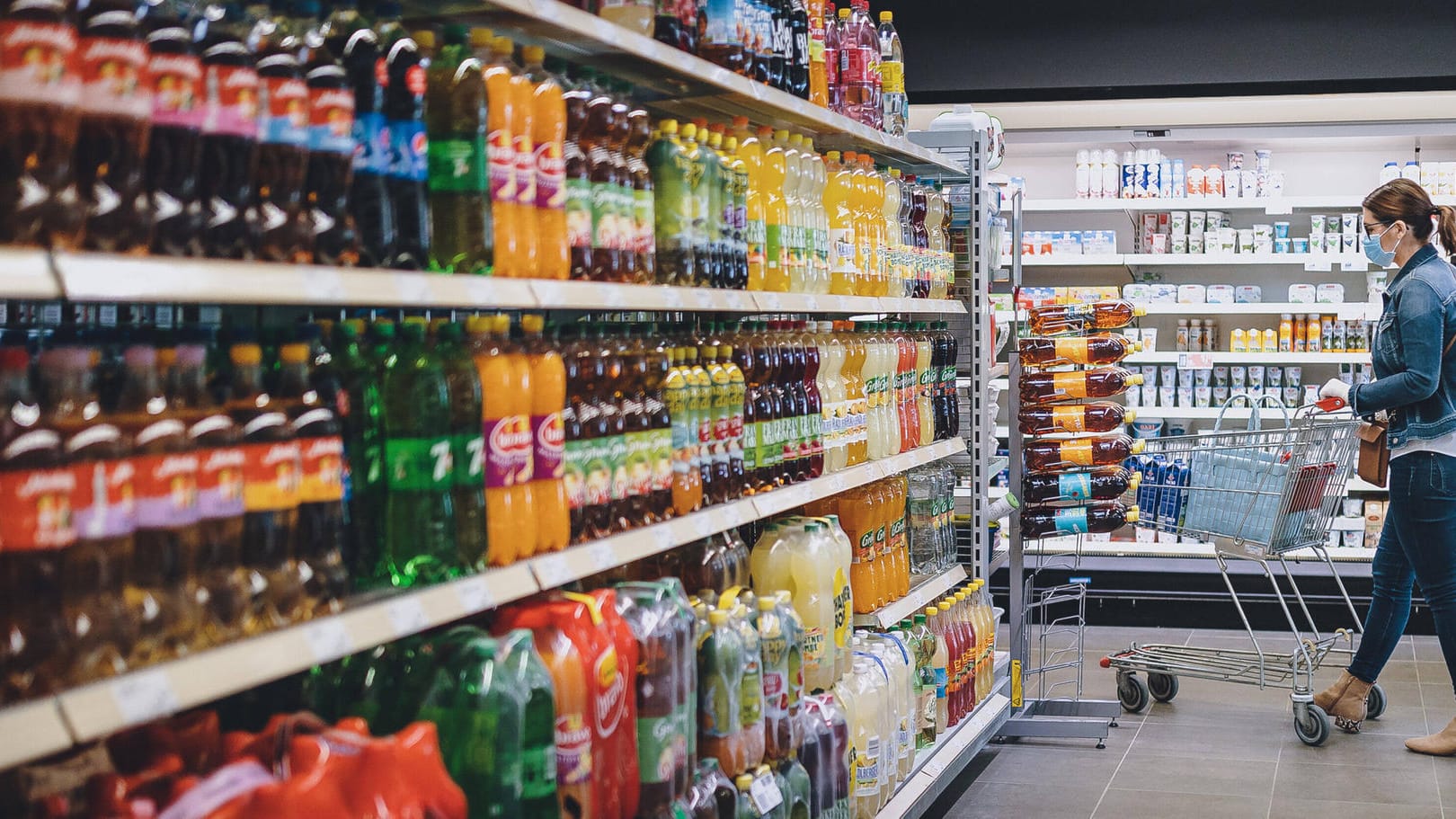 Eine Frau geht mit einem Einkaufswagen an dem Getränkeregal eines Supermarktes vorbei (Symbolbild): In München hat eine 56-Jährige Flaschen manipuliert und Getränke vergiftet. Eine Frau geht mit einem Einkaufswagen an dem Getränkeregal eines Supermarktes vorbei (Symbolbild): In München hat eine 56-Jährige Flaschen manipuliert und Getränke vergiftet.