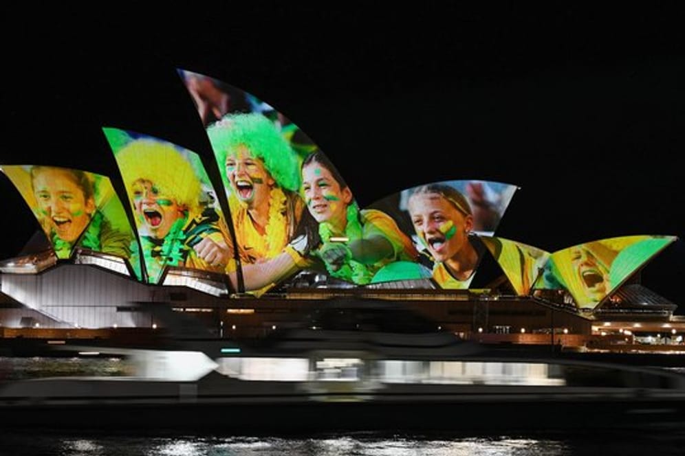Australien und Neuseeland sind die Gastgeber der Frauenfußball-Weltmeisterschaft 2023: Das Opernhaus wird mit leuchtenden bunten Fotos von Fußball-Fans angestrahlt.