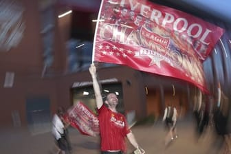 Ein Fan des FC Liverpool schwenkt feiert seinen Verein.