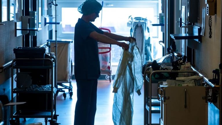 Eine Krankenschwester legt auf einer Corona-Isolierstation Schutzkleidung an.