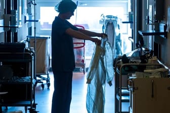Eine Krankenschwester legt auf einer Corona-Isolierstation Schutzkleidung an.