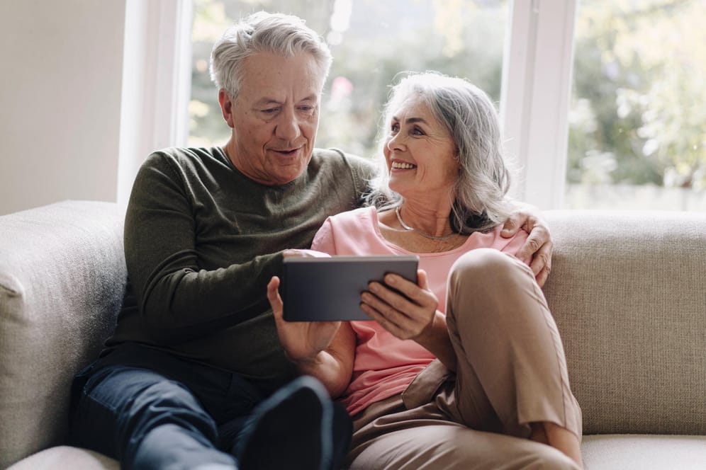 Ein älteres Ehepaar (Symbolbild): Ihre Rente können Sie ganz einfach vom heimischen Sofa aus berechnen.