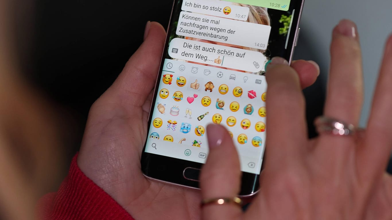 Eine Nutzerin wählt Emojis in WhatsApp aus: Bald könnten auch animierte Sticker dazu kommen.