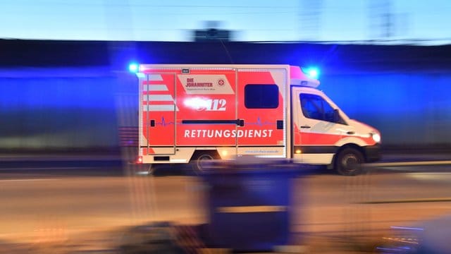Ein Rettungswagen ist mit eingeschaltetem Blauchlicht im Einsatz: In Berlin hat ein mutmaßliches Autorennen zu einem Unfall geführt.