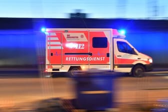 Ein Rettungswagen ist mit eingeschaltetem Blauchlicht im Einsatz: In Berlin hat ein mutmaßliches Autorennen zu einem Unfall geführt.