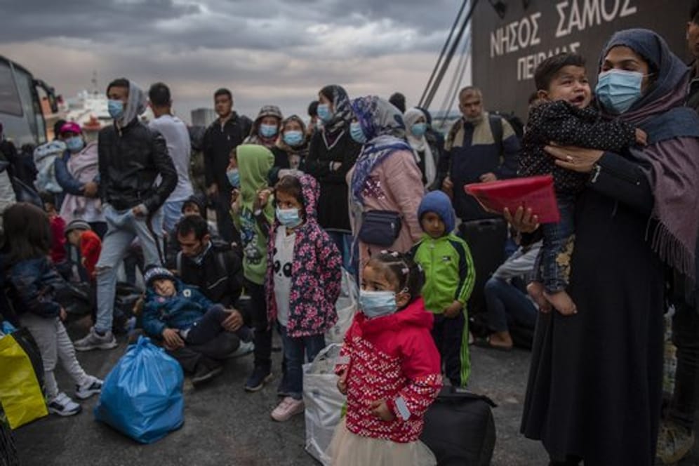 Flüchtlinge aus dem Lager Moria auf Lesbos gehen im Hafen von Piräus bei Athen an Land.