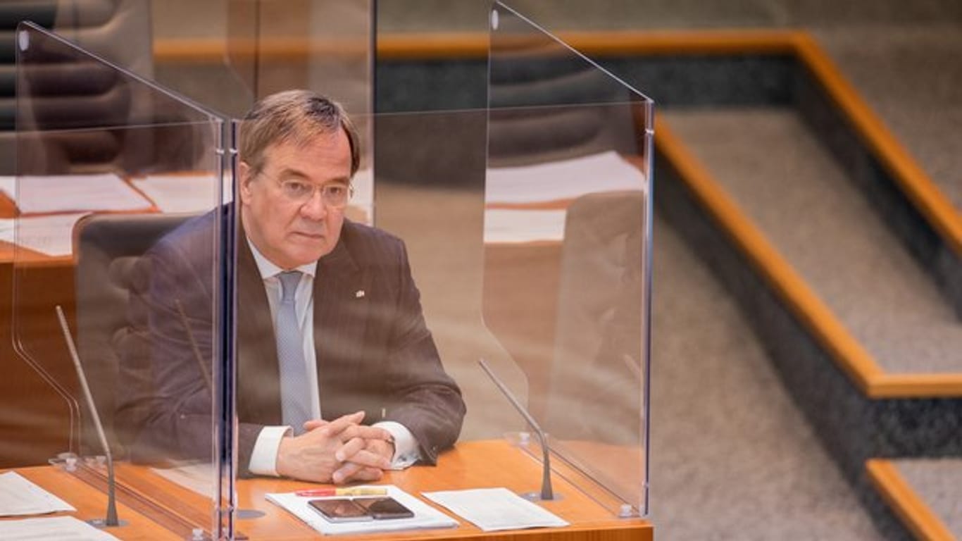 NRW-Ministerpräsident Armin Laschet sitzt im Plenum des Düsseldorfer Landtags in einer Plexiglas-Box.