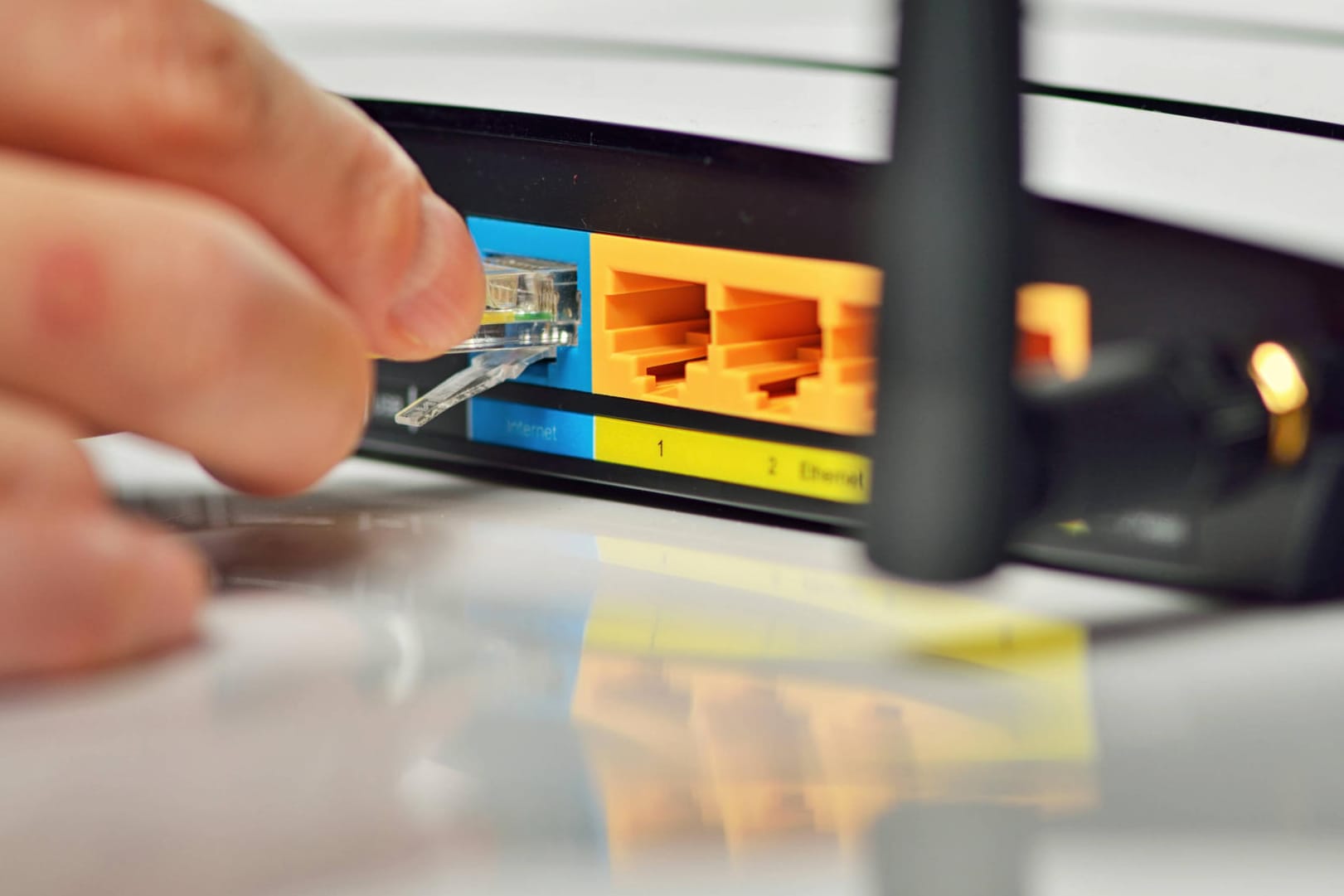 Nutzer steckt ein Netzwerkkabel in einen Router: Wissenschaftler fanden in allen getesteten Geräten Sicherheitsmängel.